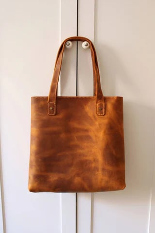 a brown leather tote bag with a leather tote bag