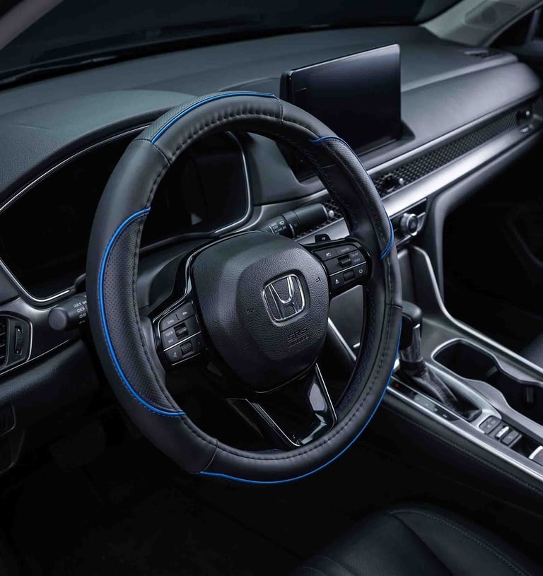 Black leather steering wheel cover with blue trim installed in a modern car interior dashboard.