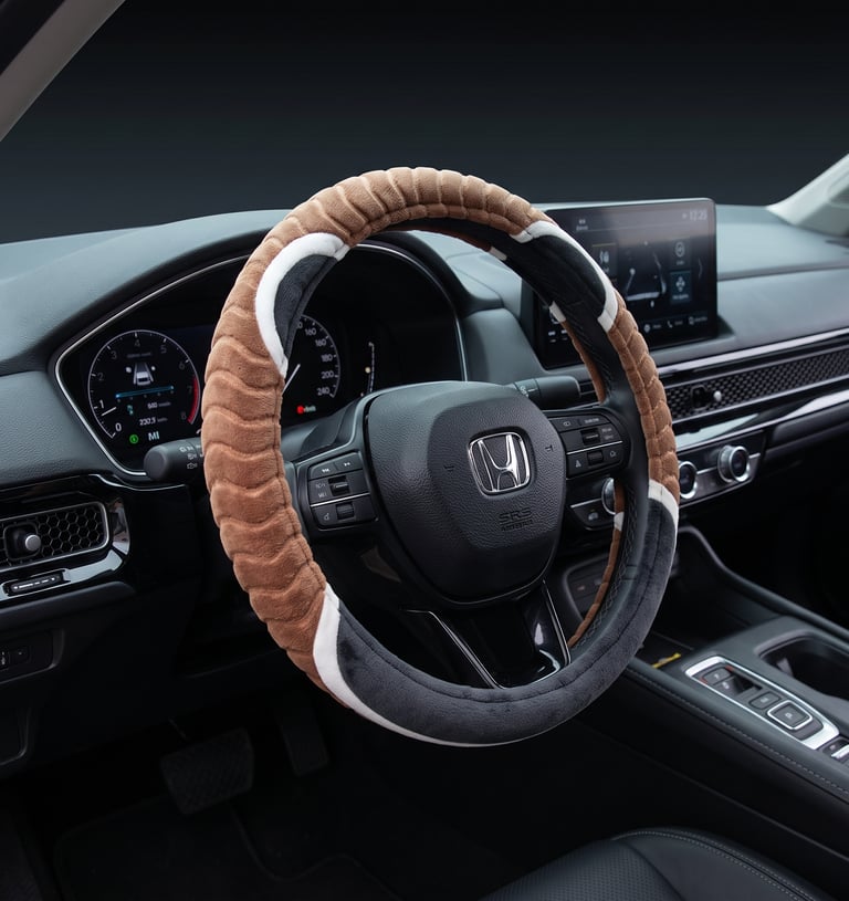 A plush brown and black fuzzy steering wheel cover installed in a modern Honda car interior.