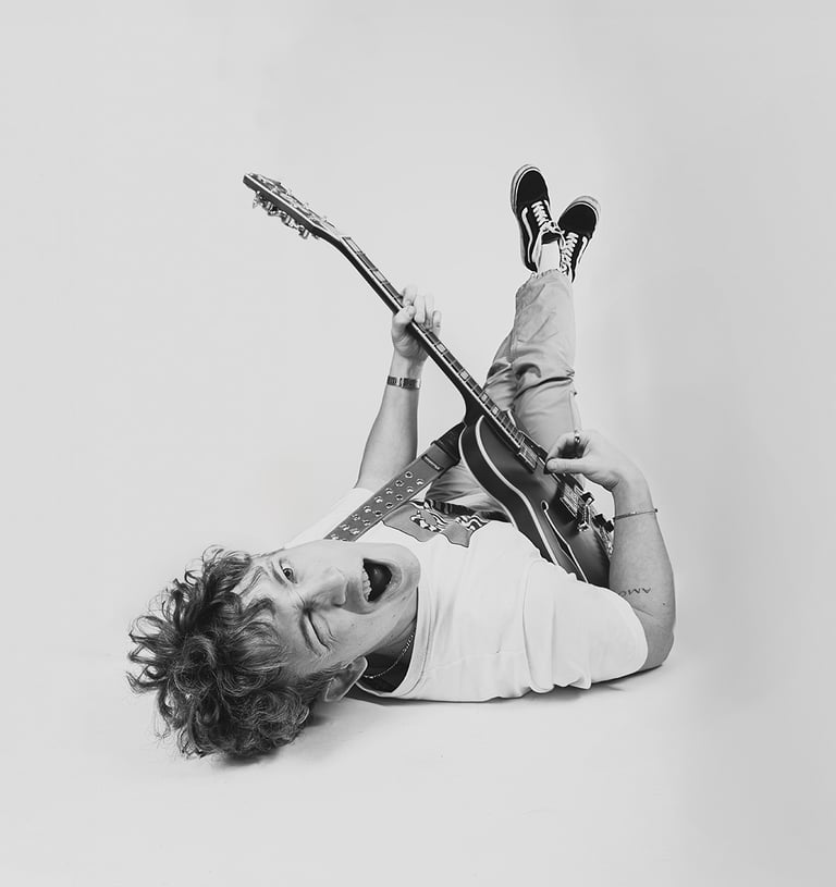 zwart-wit studioportret van gitarist met elektrische gitaar