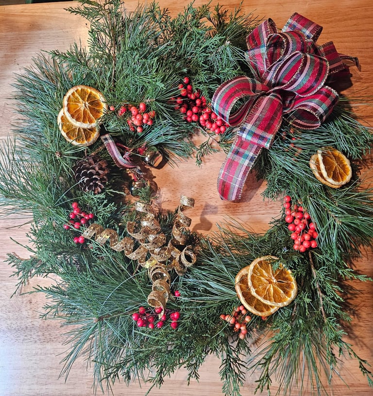a wreath made of pine cones and oranges