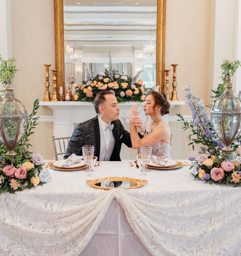 a man and woman sitting at a table with flowers