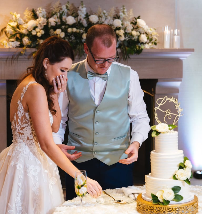a man and woman cutting their wedding cake