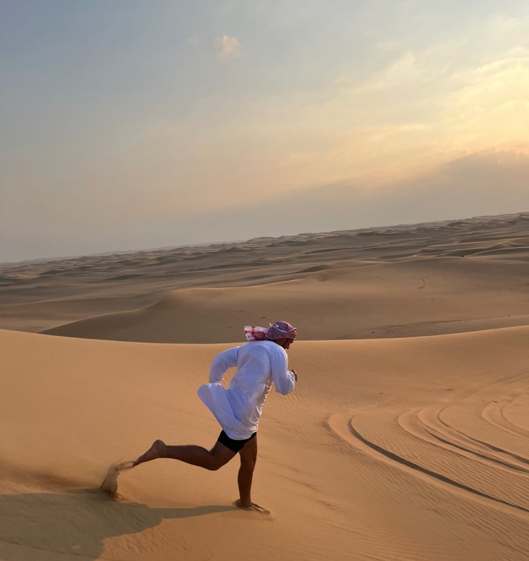 a man in a white shirt is running through the desert