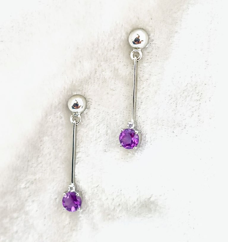 a pair of earrings with Amethyst