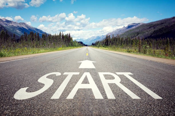 Start here written on roadway with beautiful background