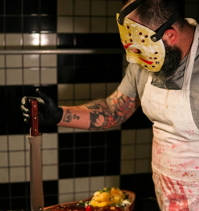 Blood-soaked man with knife in kitchen representing Grindhouse Gore Edition of Trivia from the Grave