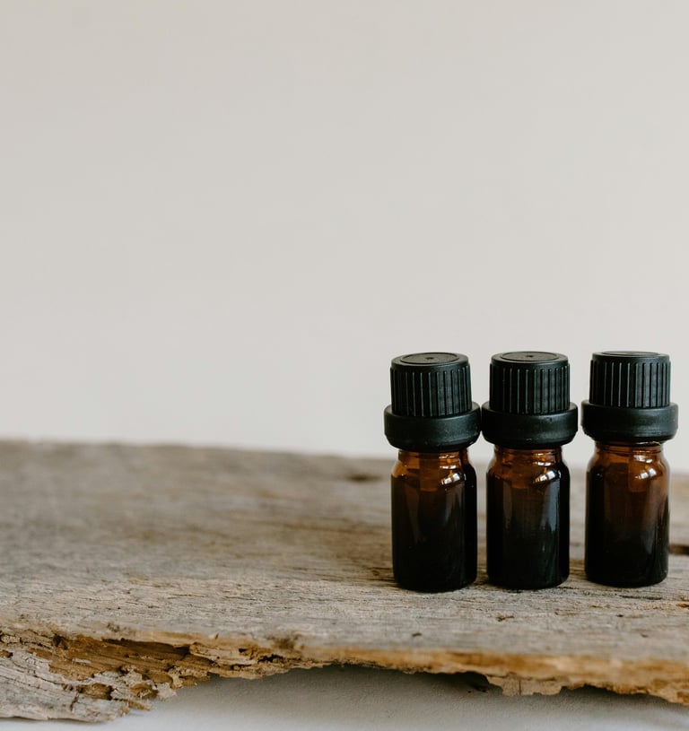 three bottles of essential oils on a wooden surface