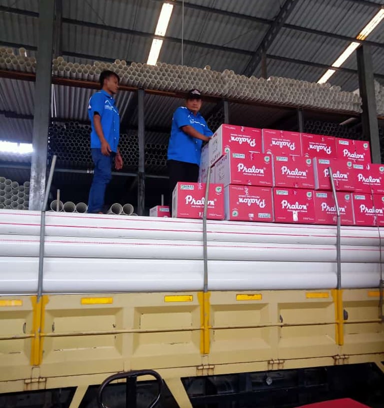 two men standing on a truck with boxes fittings pralon knee pipa pvc