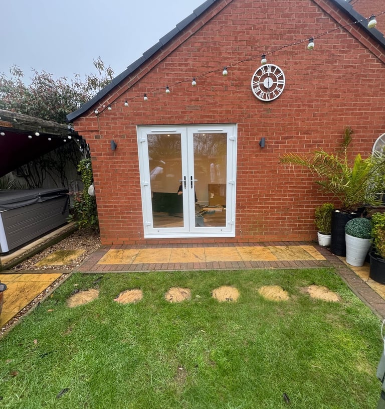 Side aspect of converted garage with French doors