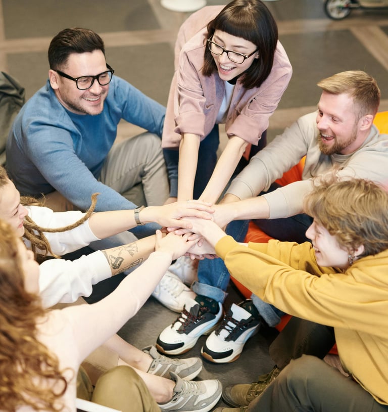 a group of people sitting around a group of people holding hands