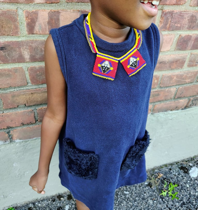 a young girl with a colorful necklace which is the part of the traditional regalia of Eswatini