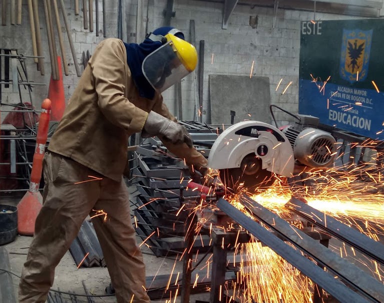 a man in a welding helmet grinding a piece of metal