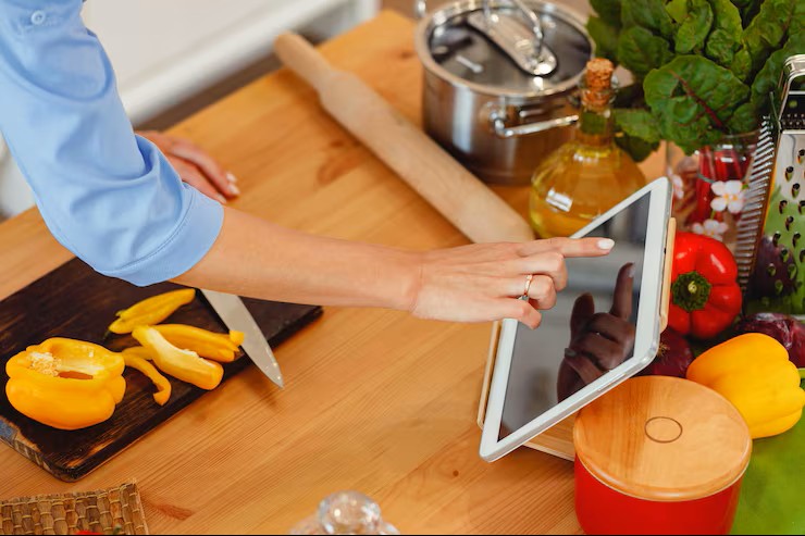 Estudiante aprendiendo vocabulario mientras cocina en cursos dinámicos de idiomas.
