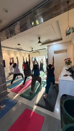 Students in Warrior Pose variation during class