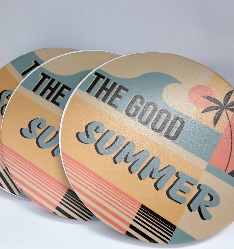 Set of retro round drink coasters with a palm tree beach sunset design and The Good Summer text.