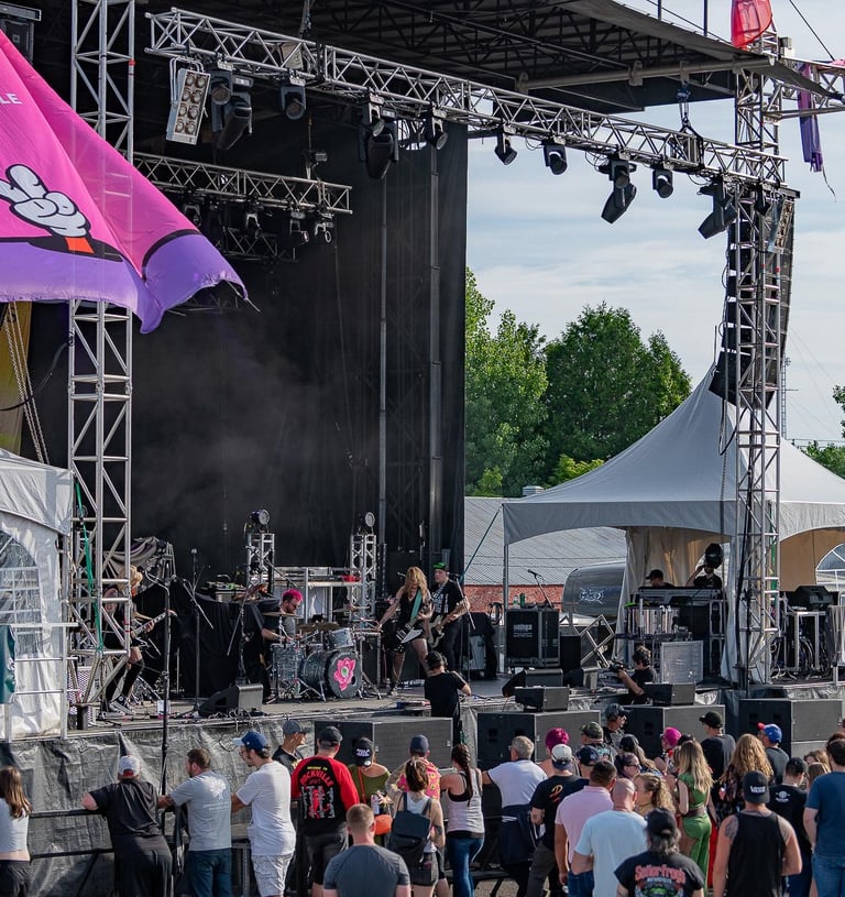 Live rock band performing on a large outdoor concert stage at VictoFest in Victoriaville.
