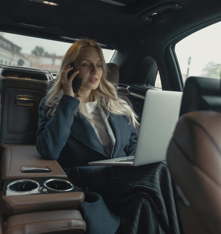a woman in a suit and sunglasses sitting in a car