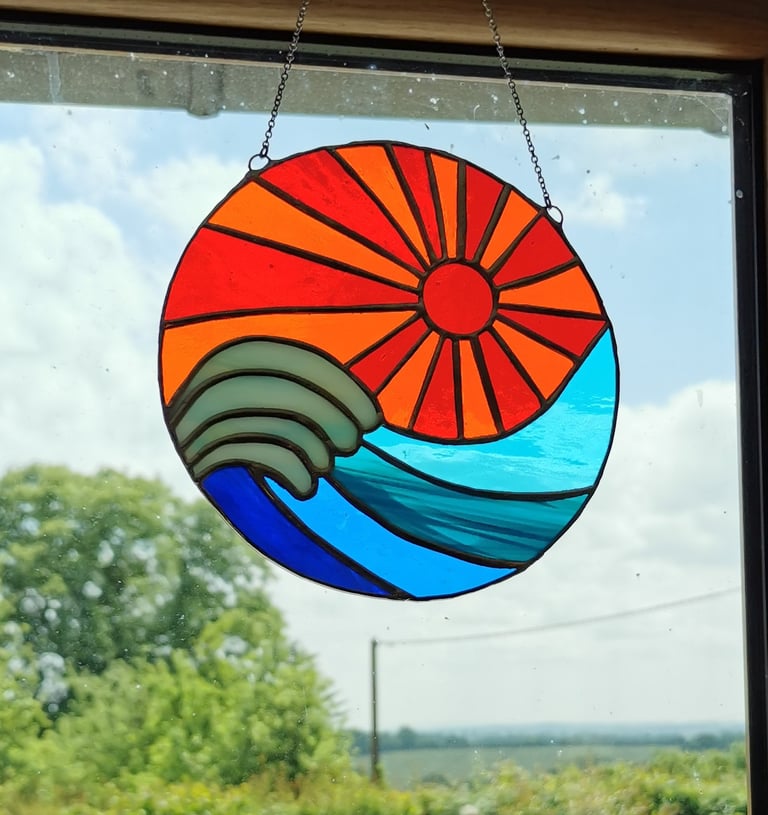 a sun catcher with a sun shining through the window