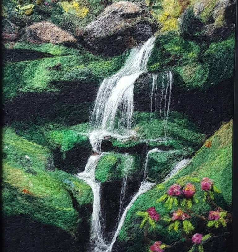 a wool felt fiber art painting of a waterfall in a forest