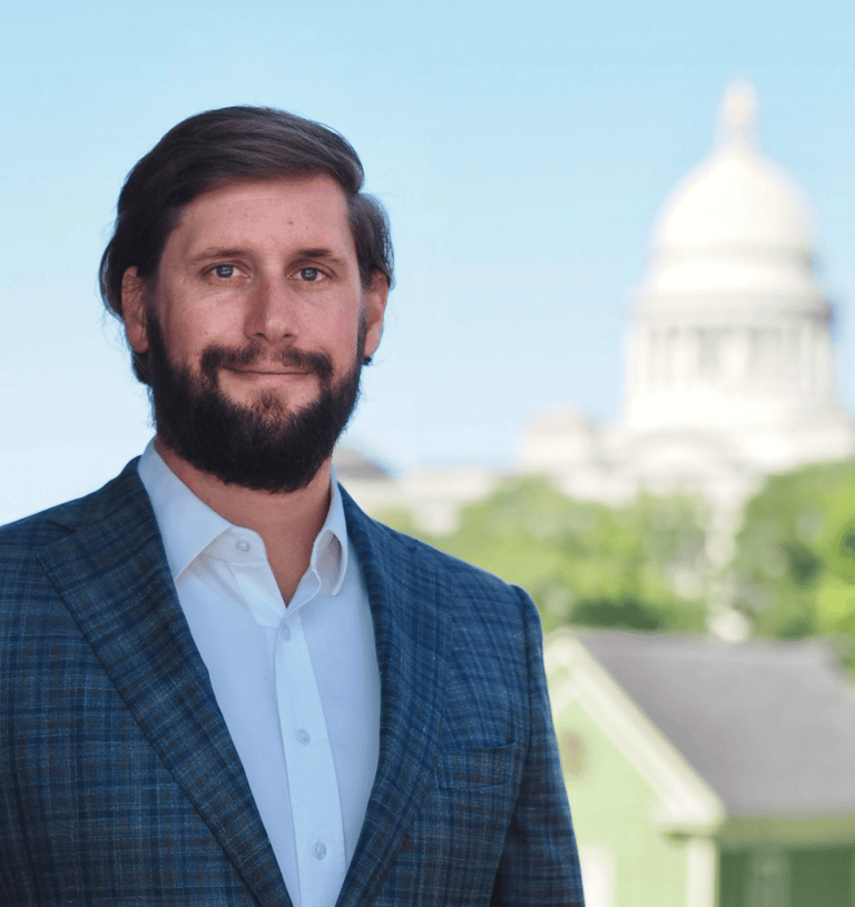 Arkansas Criminal Defense Attorney Kyle Ludwig poses in front of the Arkansas Capitol building. 