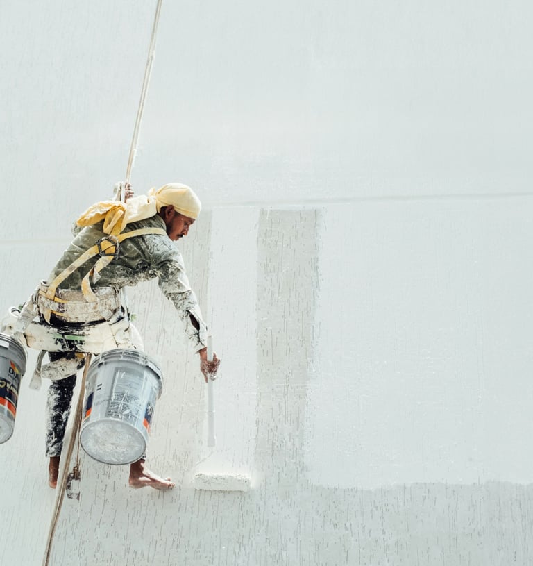 a man in a white shirt painting a wall