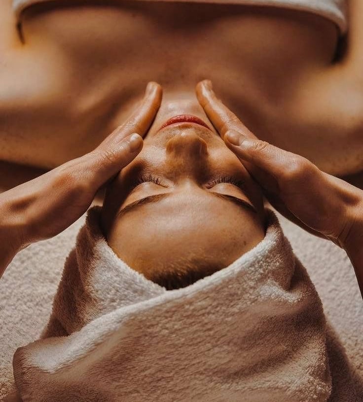 a woman getting a facial massage at a spa