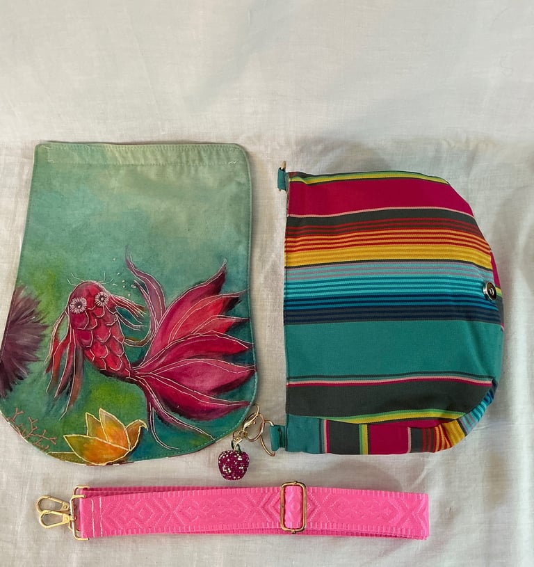 Handmade silk koi fish crossbody bag with a colorful striped pattern and a pink adjustable strap.