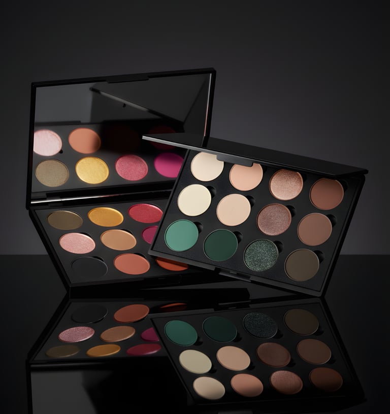 Two professional matte and shimmer eyeshadow palettes featuring neutral and bold pigments on a reflective surface.