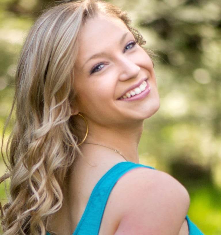 a woman in blue smiling and looking at the camera
