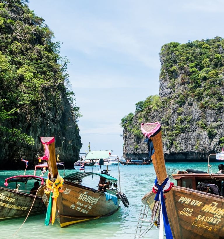 Barcos tradicionais tailandeses ancorados na Ilha Phi Phi, em Phuket, destino popular de cruzeiros pela Ásia