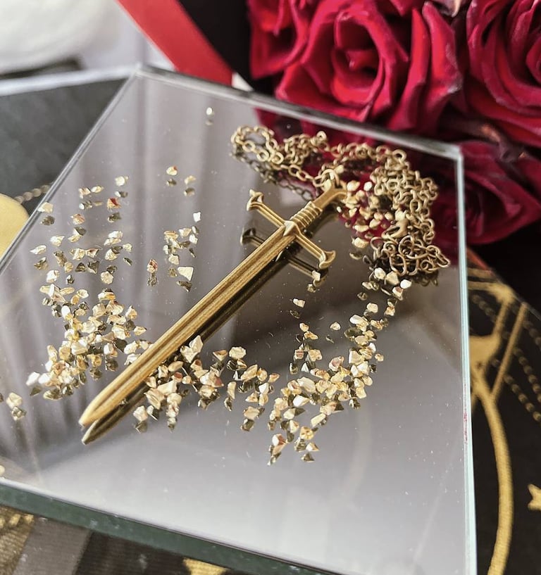 a gold sword accessory on a table