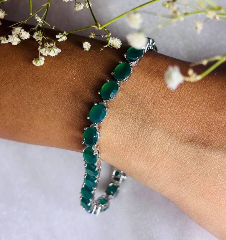 a woman's bracelet with green Emerald beads