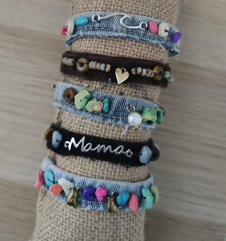 plusieurs bracelets faits main en jean de differentes couleurs avec depetites breloques accrochées