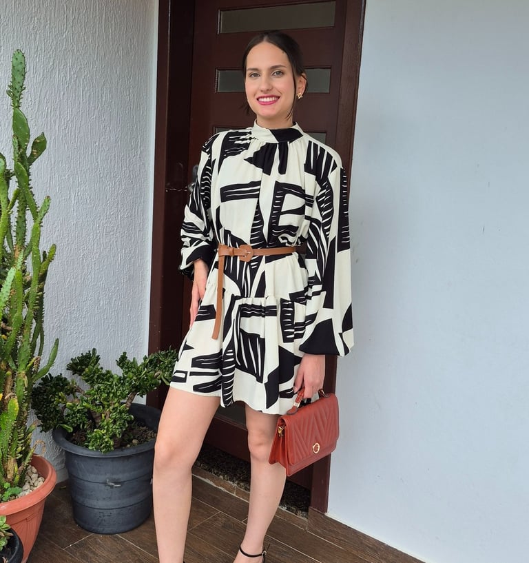 Mulher usando vestido amplo com cinto e usando uma bolsa marrom