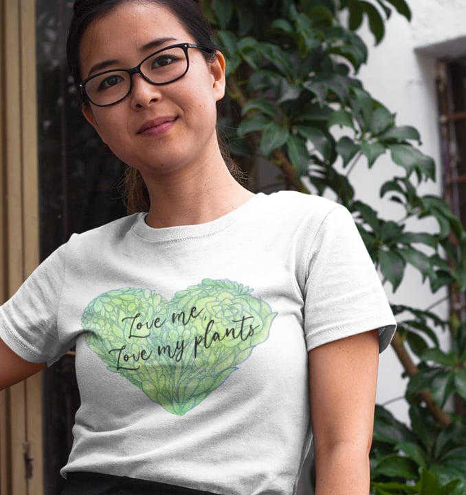Woman wearing Miss Chatty Plants “Love Me, Love My Plants” white t-shirt with green heart design