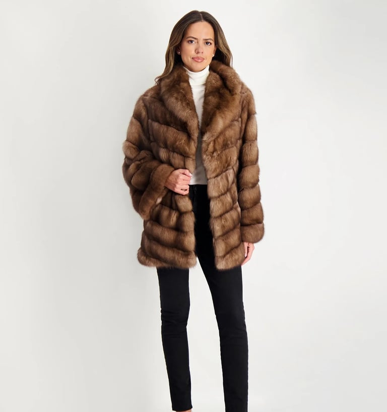 a woman in a brown gorski fur coat and black pants