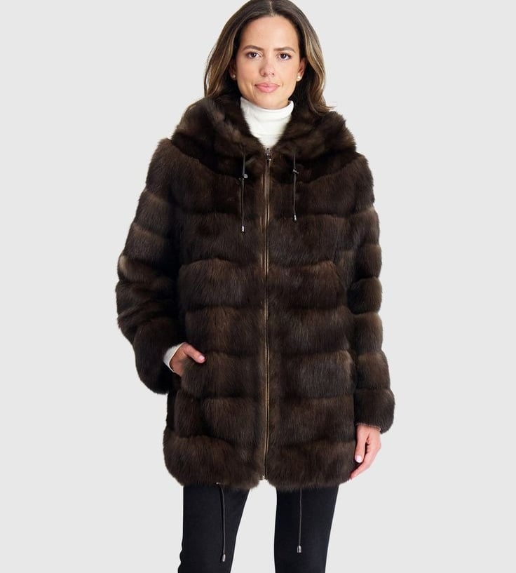 a woman in a brown gorski coat with a hoodie