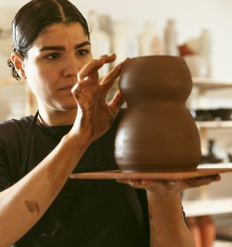 mulher esculpindo vaso em argila