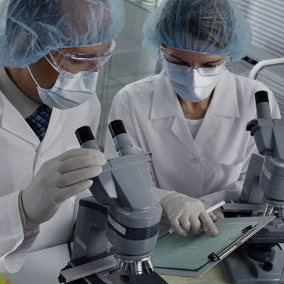 two people in lab coats and surgical masks