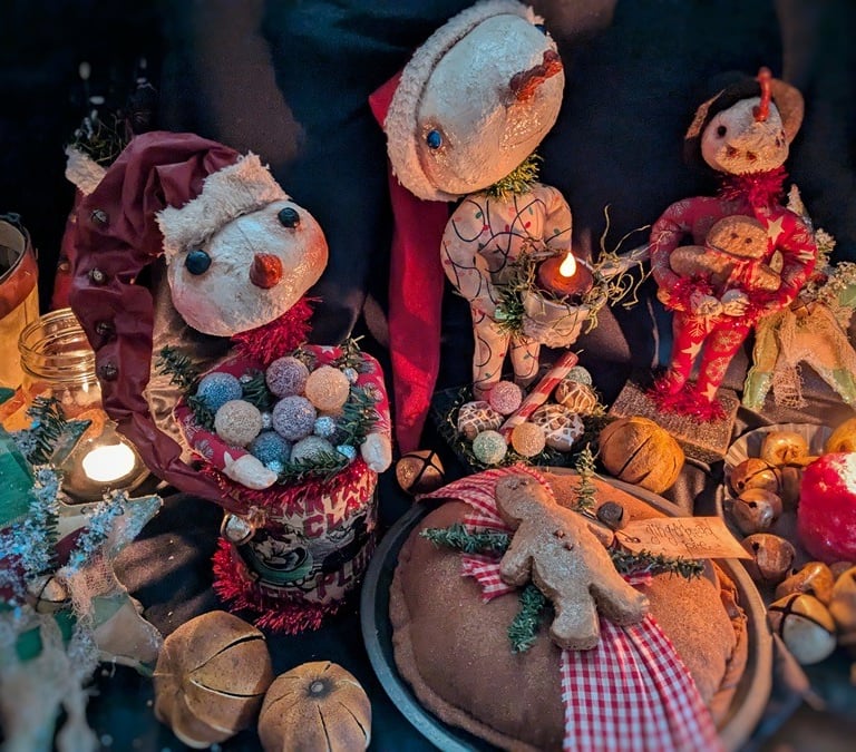 a group of rustic christmas decorations including a primitive santa clause and snowman