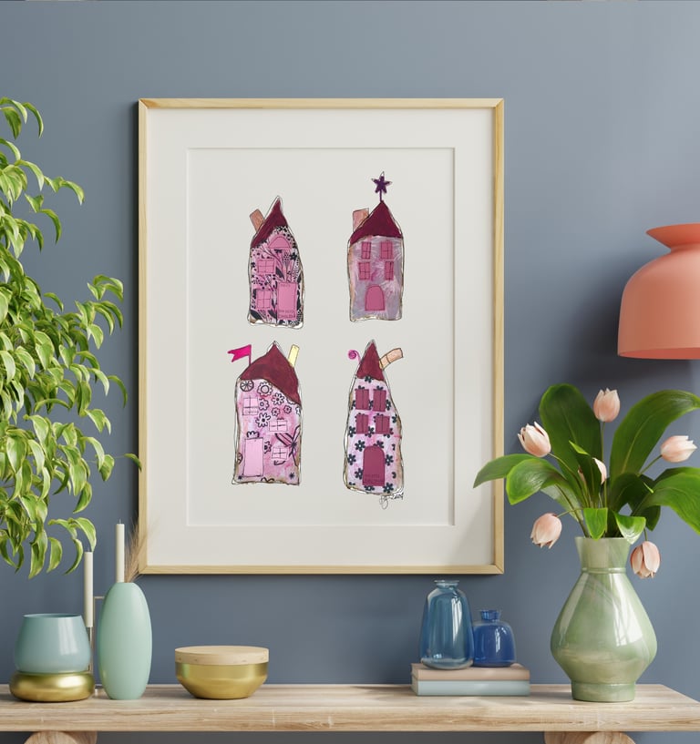 a picture of four whimiscal houses and a vase with flowers along with vases on a table