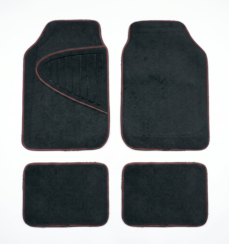 Set of four black carpet car floor mats with red stitching for vehicle interior protection.