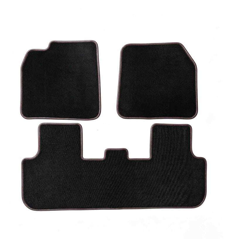 A set of three black custom car floor mats with red stitching for interior vehicle protection.