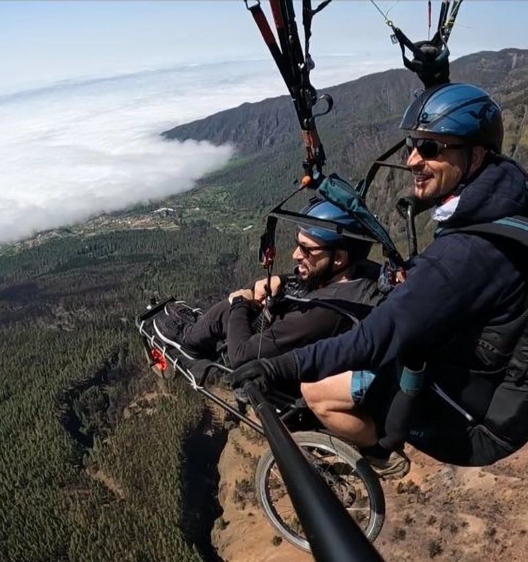 Dos personas sonriendo practican parapente adaptado en Tenerife