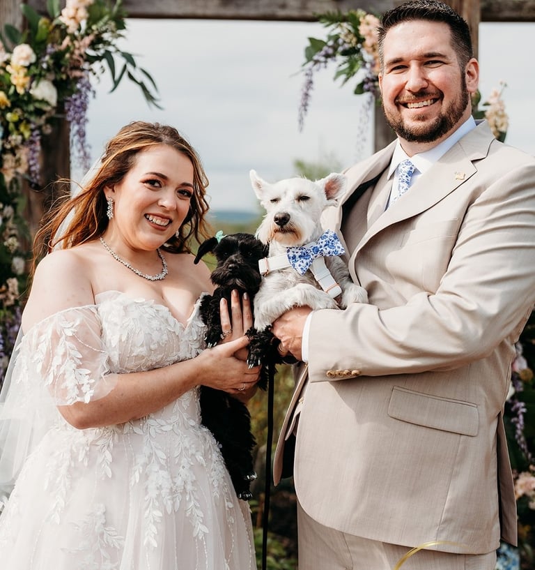 a man and woman holding a dog in a wedding ceremony