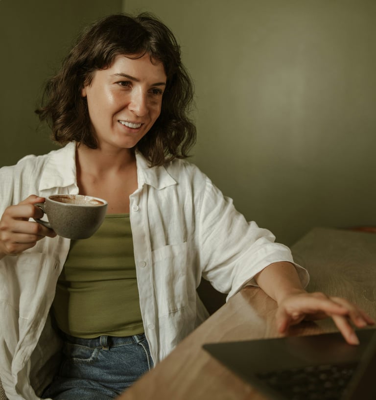 a woman sitting at a desk with a cup of coffee