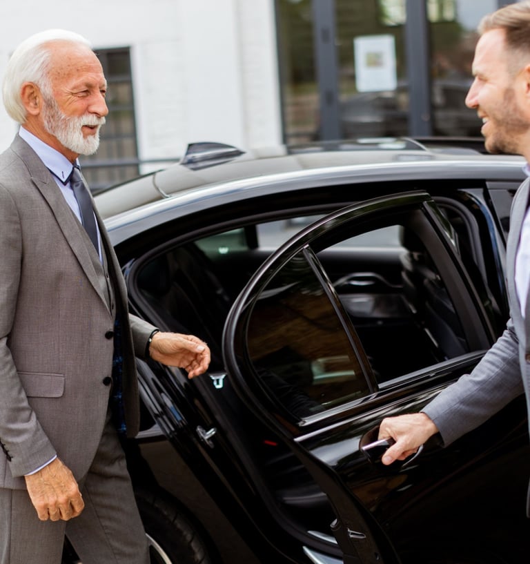 a man in a suit and tie is standing in front of a car