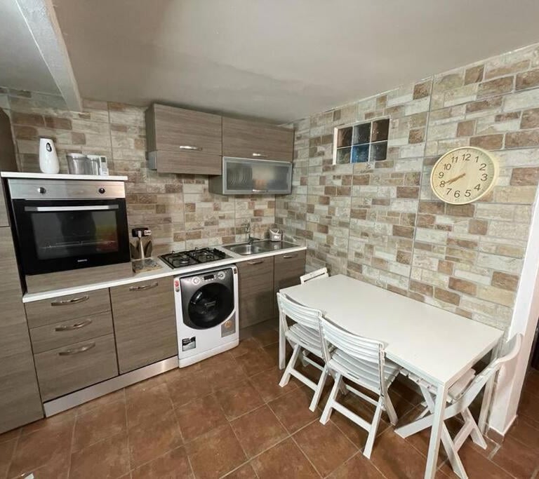 una cucina con tavolo, sedie e orologio