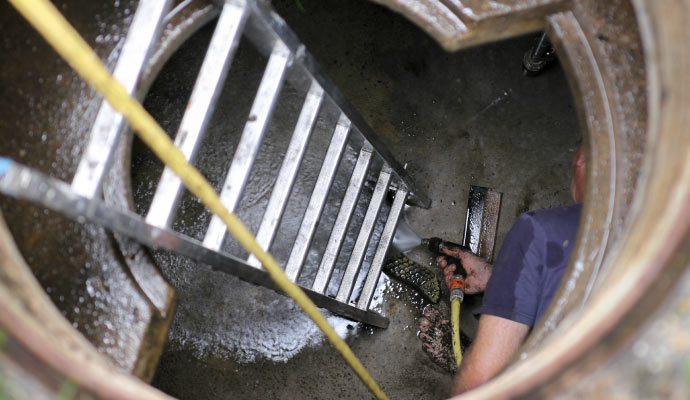a man in a blue shirt is cleaning a cistern